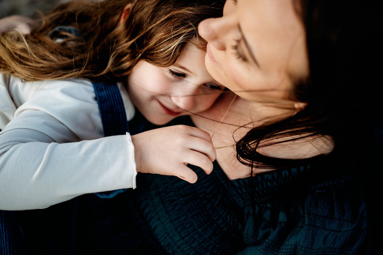 Mum pressing her cheek to her son's in a warm hug